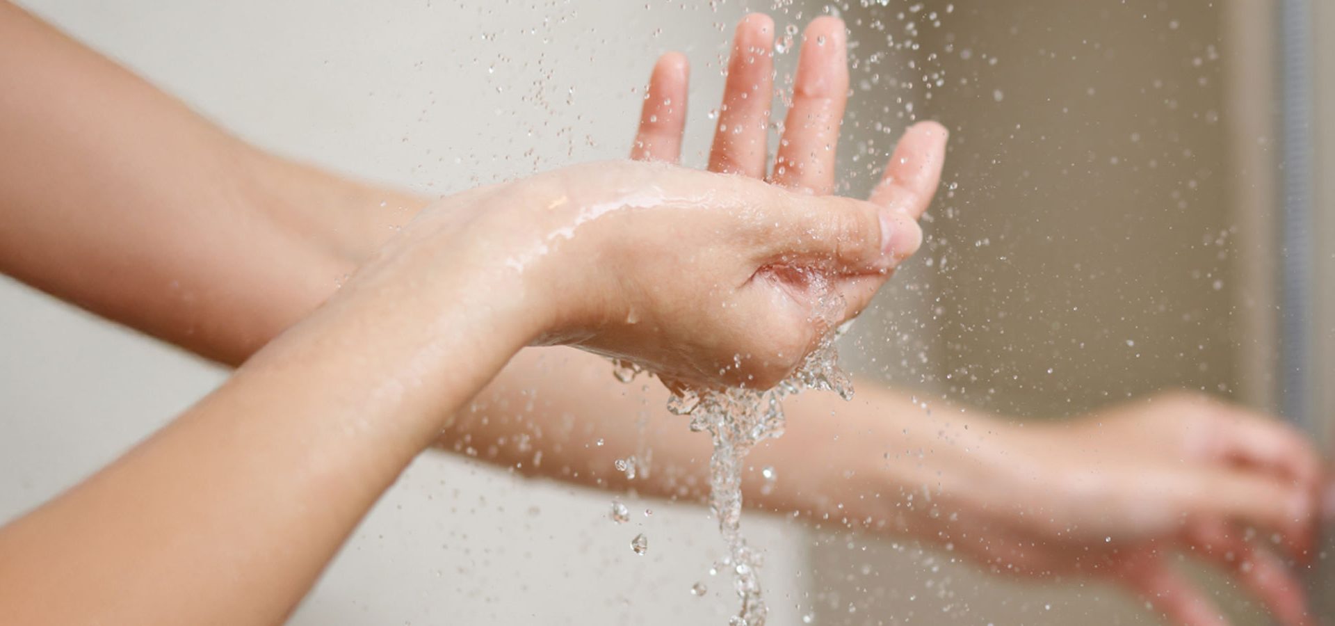 Manos de una mujer lavándose con agua tibia, representando el cuidado de la higiene íntima femenina